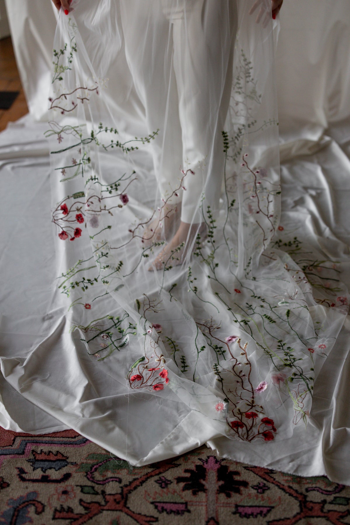 Close-up of the Blath Beag floral veil train with embroidered red and pink wildflowers on ivory tulle – Mizz Rio