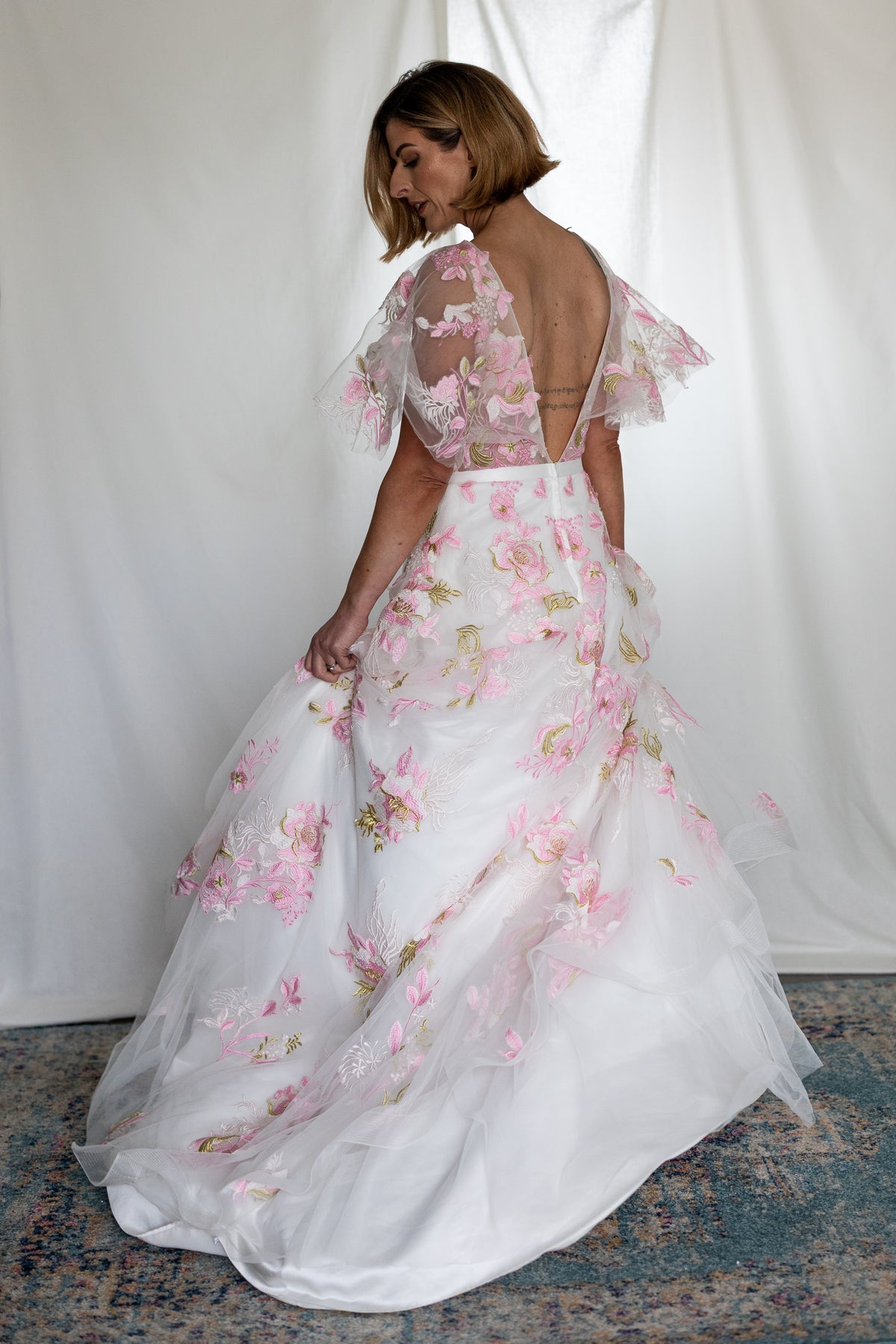 Pink floral embroidered wedding dress with sheer flutter sleeves and layered tulle skirt — modern romantic alternative bridal gown by Mizz Rio in Ireland 