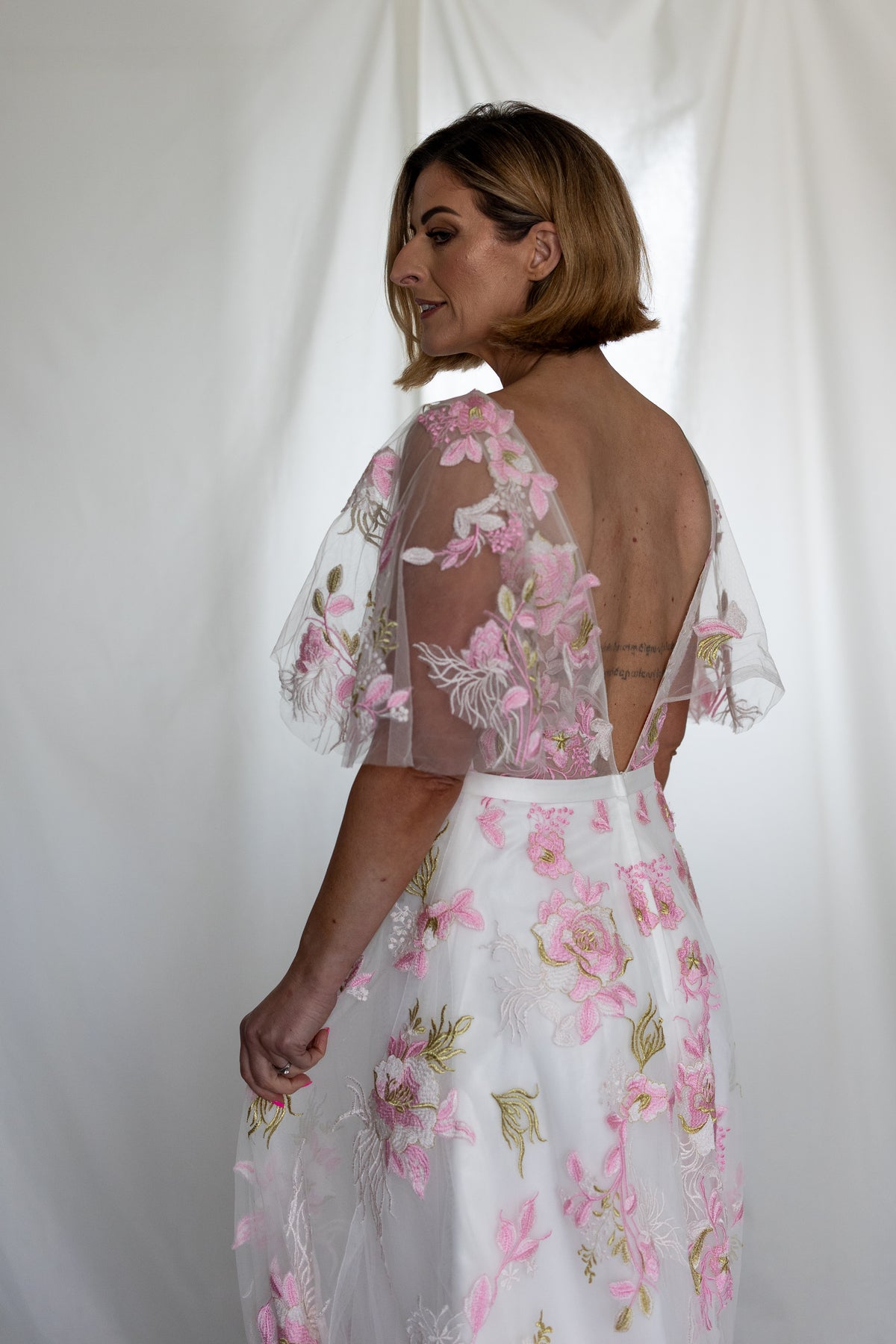 Pink floral embroidered wedding dress with sheer flutter sleeves and layered tulle skirt — modern romantic alternative bridal gown by Mizz Rio in Ireland 