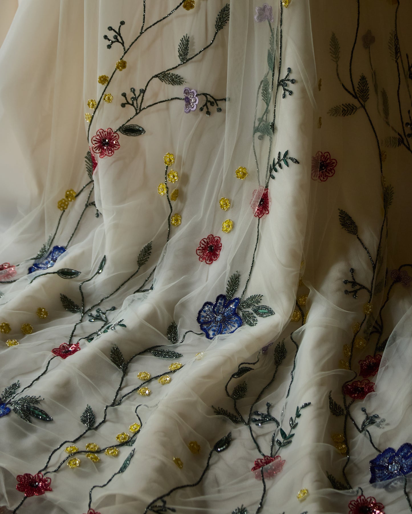 Couture bridal veil hand-embroidered with colourful Irish wildflowers, worn by modern bride in minimalist ivory wedding dress, designed by Mizz Rio in Dublin