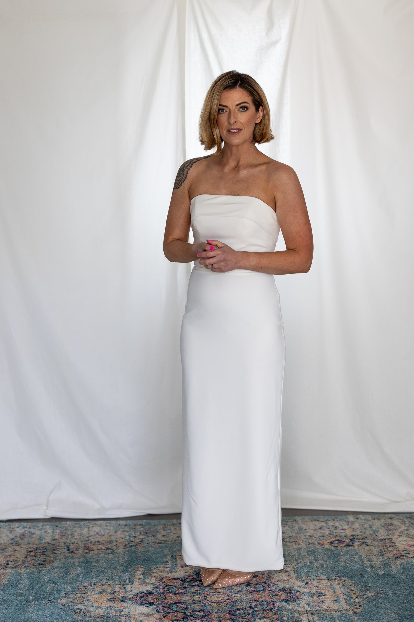 Minimalist strapless column wedding dress with clean satin lines, photographed on bride in studio — modern alternative bridal look by Mizz Rio in Ireland