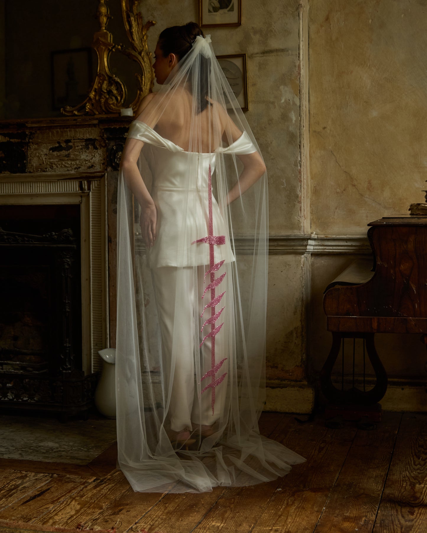 Modern bride in ivory mini dress and trousers wearing sheer tulle couture bridal veil with vertical pink sequin bra motif by Mizz Rio, alternative wedding look in Dublin