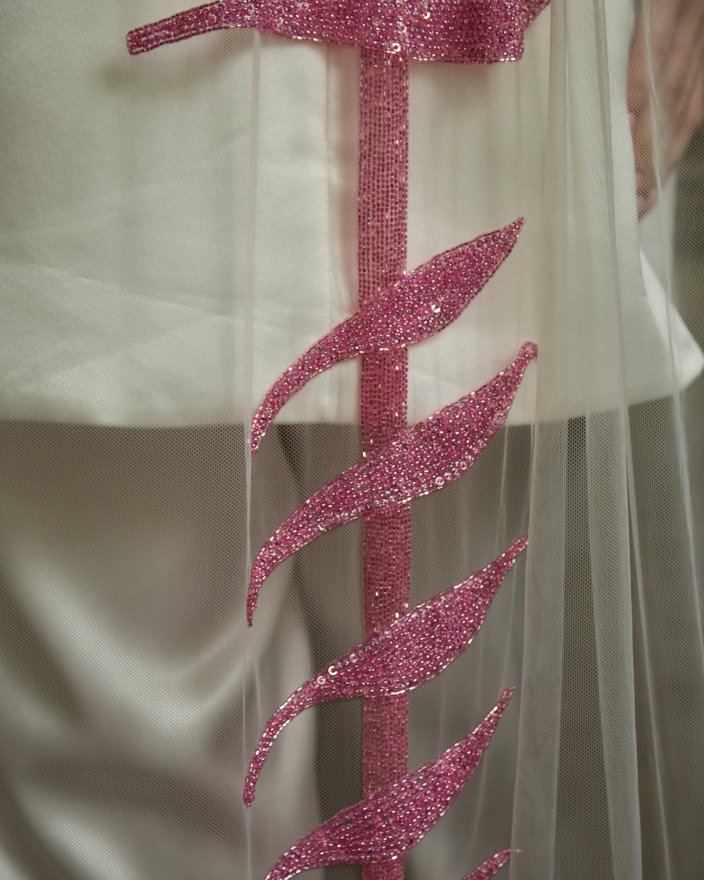 Modern bride in ivory mini dress and trousers wearing sheer tulle couture bridal veil with vertical pink sequin bra motif by Mizz Rio, alternative wedding look in Dublin