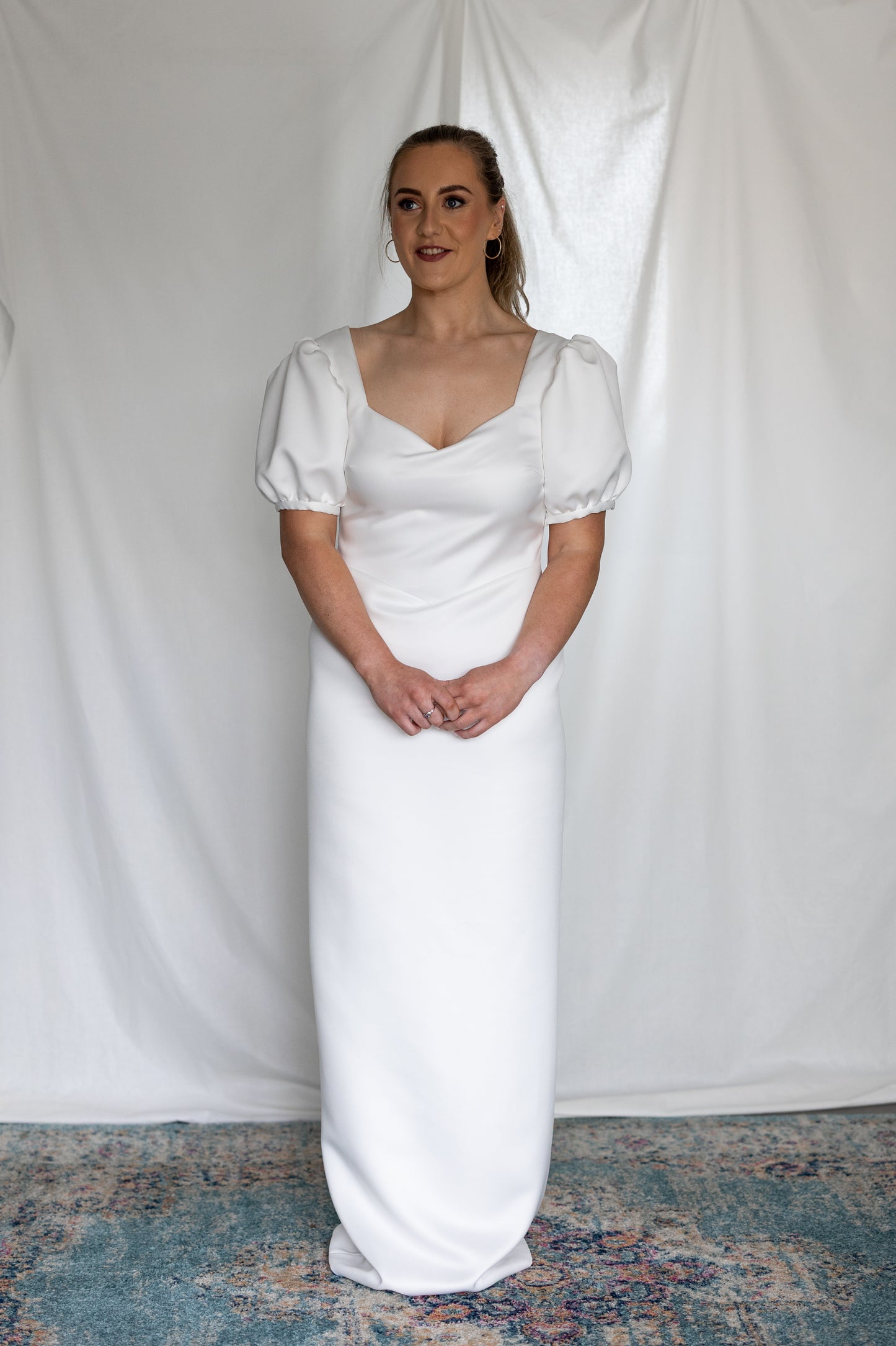 Minimalist white wedding gown with basque waistline and statement puff sleeves — modern column silhouette handcrafted by Mizz Rio in Ireland 