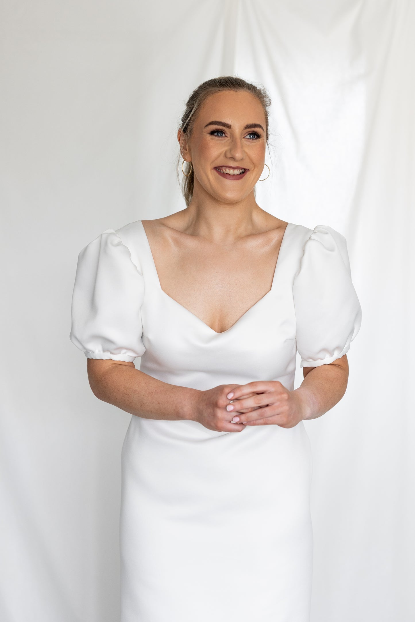 Minimalist white wedding gown with basque waistline and statement puff sleeves — modern column silhouette handcrafted by Mizz Rio in Ireland 