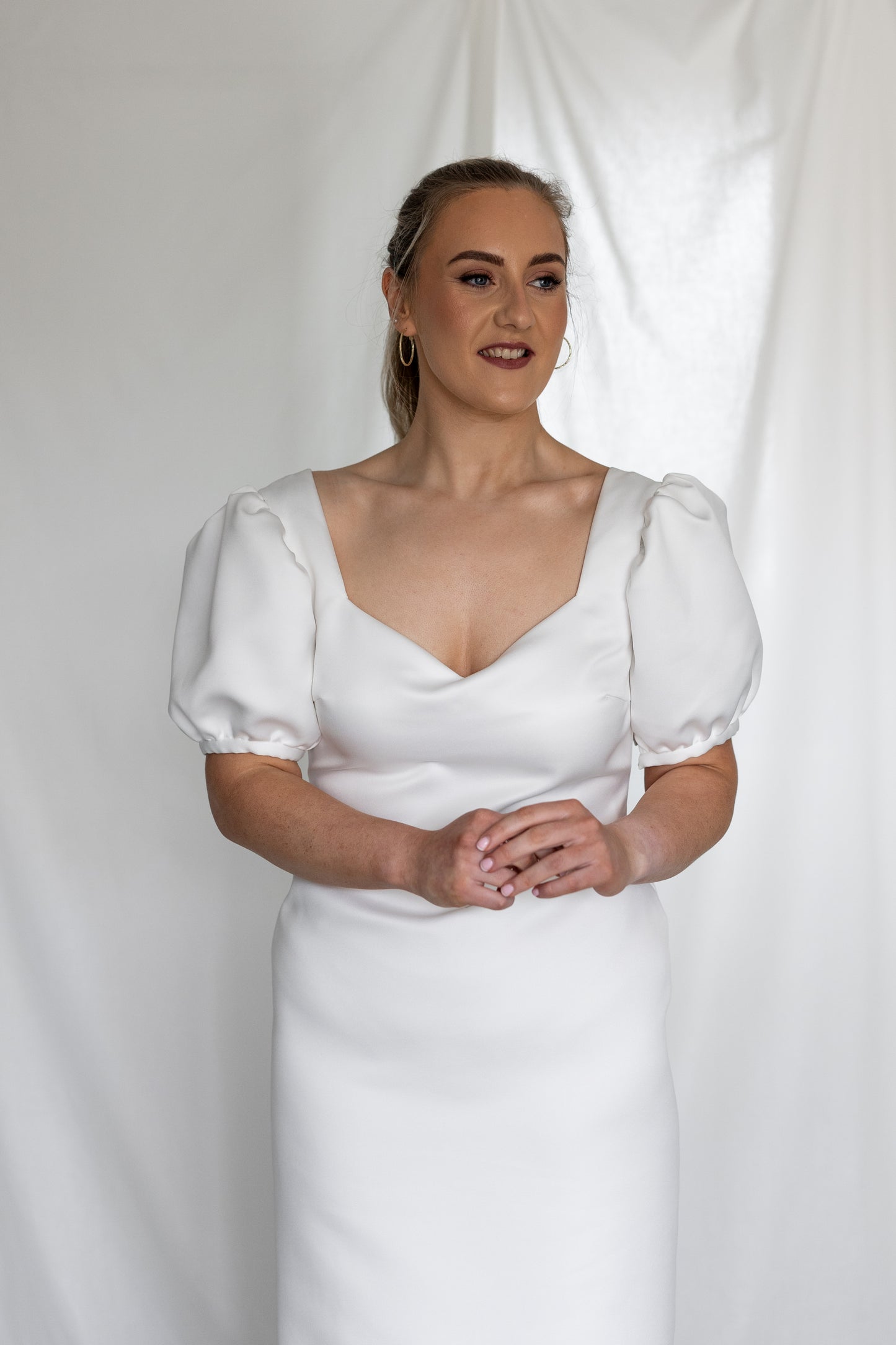 Minimalist white wedding gown with basque waistline and statement puff sleeves — modern column silhouette handcrafted by Mizz Rio in Ireland 
